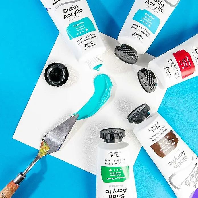 Mont Marte Acrylfarbe Premium - Türkis, 75 ml, Tube - Auswahl an Mont Marte Satin Acrylfarben in verschiedenen Tönen, mit türkiser Farbe auf einer Fläche neben einem Spachtel.