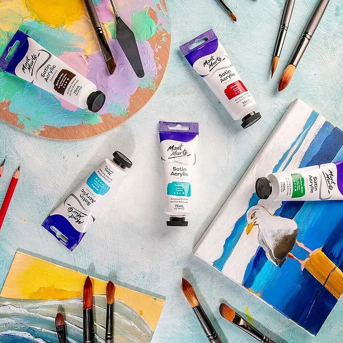 Mont Marte Acrylfarbe Premium - Türkis, 75 ml, Tube - Mont Marte Satin Acrylfarben-Tuben, Pinsel & Palette auf einem bemaltem Untergrund mit Leinwänden.