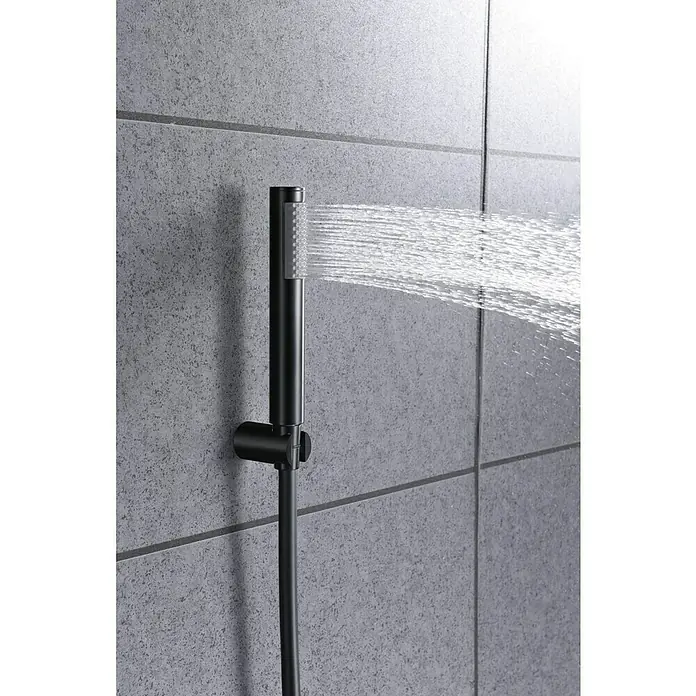 Imex Olimpo Grifo monomando de bañera - Negro, Mate - La imagen muestra una ducha de mano negra mate moderna con agua que fluye, montada con un soporte en una pared de azulejos gris.