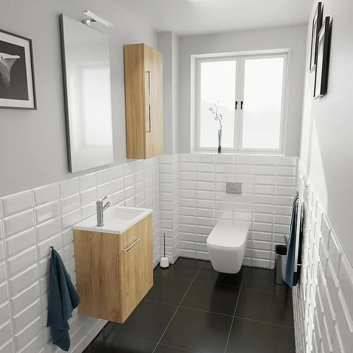 Camargue Espacio Badmöbel-Set H66 - 90 cm, Doce - Ein Badezimmer mit einem weißen Waschbeckenunterschrank aus Holz und einem weißen WC mit Spülkasten vor weißen Ziegeln.
