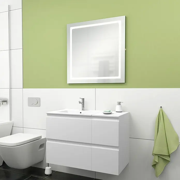 Camargue Espacio Badmöbel-Set H2 - 90 cm, Gama weiß matt - Eine Nahaufnahme eines Badezimmers mit einem beleuchteten Spiegel, einem weißen Waschtisch und einer Toilette mit Spülkasten.
