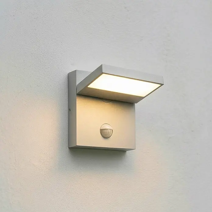 Lucande Außenwandleuchte Silvan - alu / grau / zink, alu / grau / zink, IP54 - Moderne silbergraue Außenwandleuchte mit beleuchtetem Oberteil und integriertem Bewegungsmelder.
