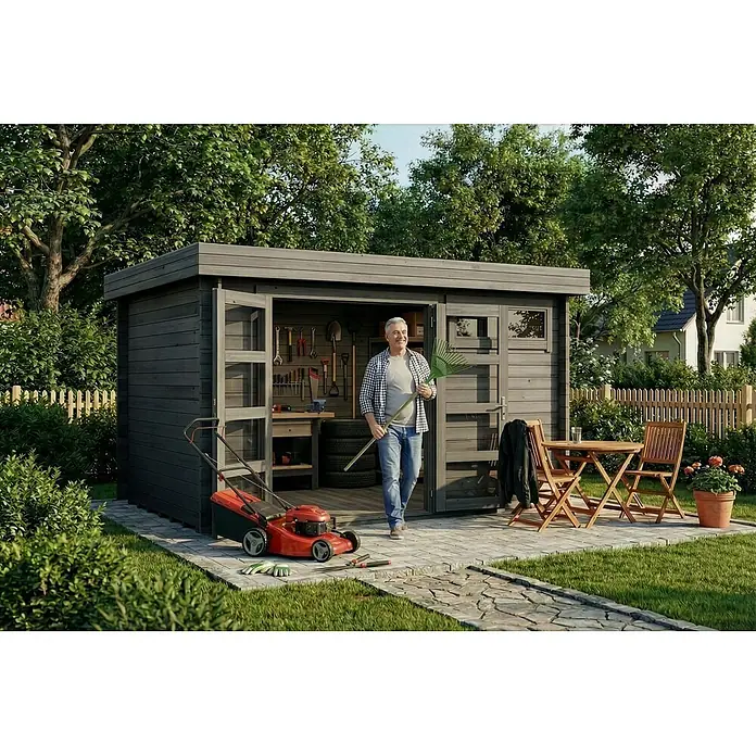 Alpholz Gartenhaus ECO Set Leandro grau 28mm Wandstärke - Außenmaß inkl. Dachüberstand (B x T): 394 x 268 cm, Holz, Grau - Dunkelgraues Holzgartenhaus in einem üppigen Garten, mit einem Mann am Eingang. Es zeigt offene Türen, Werkzeuge und eine angrenzende Terrasse.
