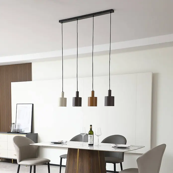 Lindby Pendelleuchte Ovelia - L x B x H: 84 x 13 x 21,5 cm, braun / rost, dunkelbraun, kaffeebraun, beige, E27 - Eine moderne lineare Pendelleuchte mit vier zylindrischen Lampen in verschiedenen Erdtönen, aufgehängt über einem Esstisch.