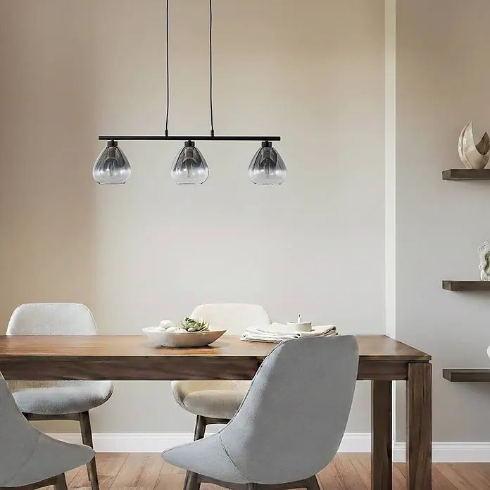 Lindby Pendelleuchte Pendura - L x B x H: 75 x 15 x 15 cm, alu / grau / zink, rauchgrau, Schwarz matt, E14 - Schwarze Pendelleuchte mit drei Rauchglas-Schirmen über einem Holzesstisch hängend.