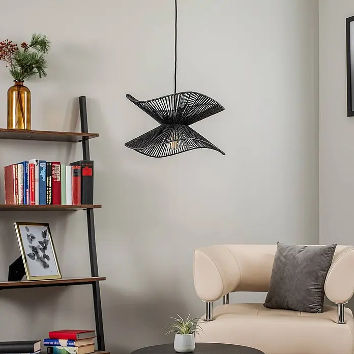 Lindby Pendelleuchte Valdorin - L x B x H: 40 x 40 x 26 cm, schwarz, Schwarz, E27 - Eine schwarze, skulpturale Hängeleuchte aus Geflecht hängt in einem modernen Wohnzimmer und spendet Umgebungslicht über einem Sitzbereich.