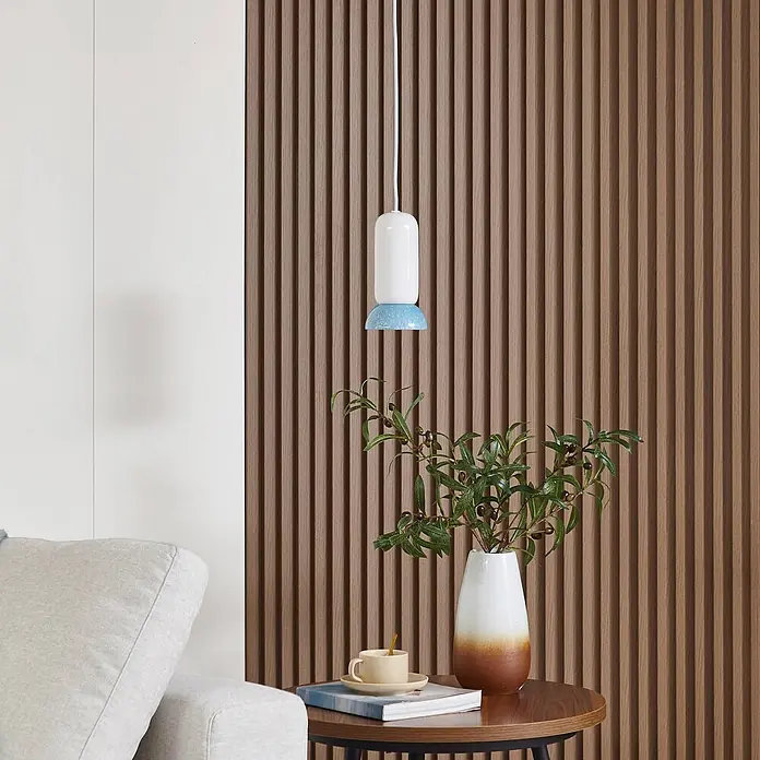 Lindby Pendelleuchte Kerimi - weiß / opal, weiß, Blau, GU10 - Eine weiß-blau gesprenkelte Pendelleuchte hängt über einem Beistelltisch in einem modernen Wohnraum.