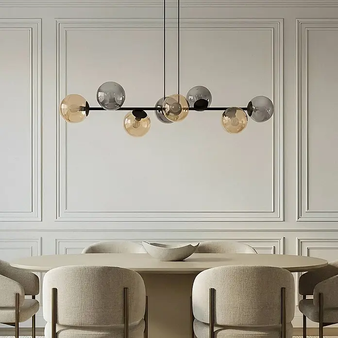 Lindby Pendelleuchte Isamer - alu / grau / zink, Schwarz, rauchgrau, amber, E14 - Moderne Hängelampe mit schwarzem Gestell und bernstein- & grauen Glaskugeln über einem Esstisch.