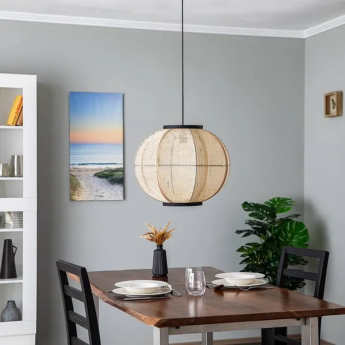 Lindby Pendelleuchte Aurinil - L x B x H: 48 x 48 x 40 cm, Holz hell, holz hell, Schwarz, E27 - Runde Hängelampe aus Geflecht mit schwarzen Akzenten, hängt über einem Esstisch.