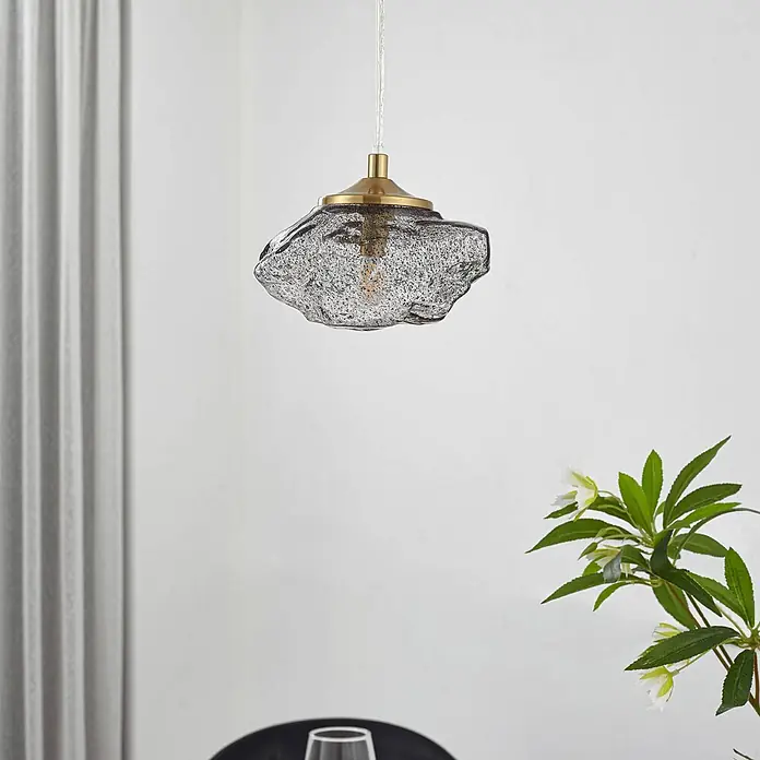 Lindby Pendelleuchte Piatra - L x B x H: 15,5 x 15,5 x 8,5 cm, schwarz, rauchgrau, messing, G9 - Pendelleuchte mit unregelmäßigem, strukturiertem grauen Glasschirm und Messingbeschlägen, von der Decke hängend.