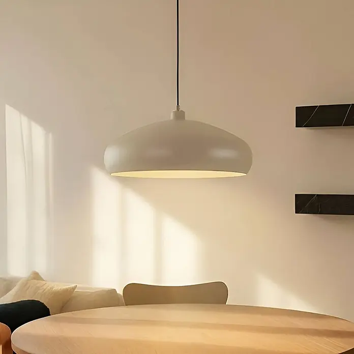 Lindby Pendelleuchte Elover - creme / amber, beige, E27 - Hellgraue, elliptische Pendelleuchte hängt beleuchtet über einem runden Holztisch.