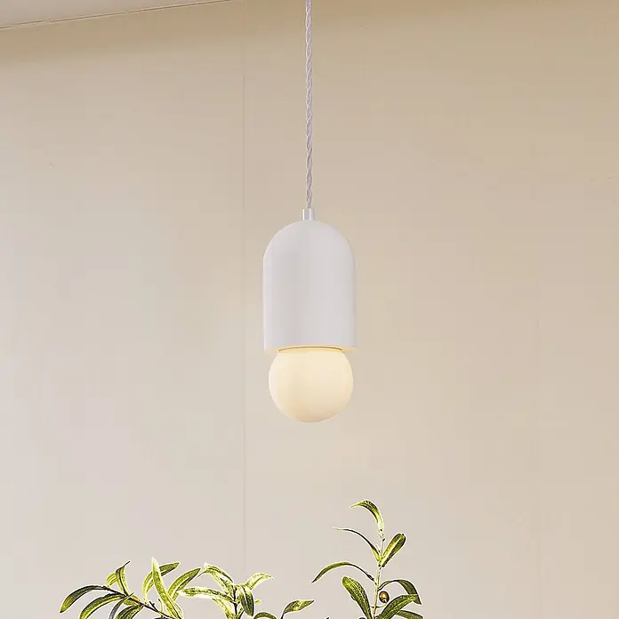 Lindby Pendelleuchte Nielson - L x B x H: 11 x 11 x 25 cm, weiß / opal, weiß, E27 - Eine moderne, weiße, pillenförmige Pendelleuchte mit einer sphärischen Glühbirne hängt beleuchtet von der Decke.