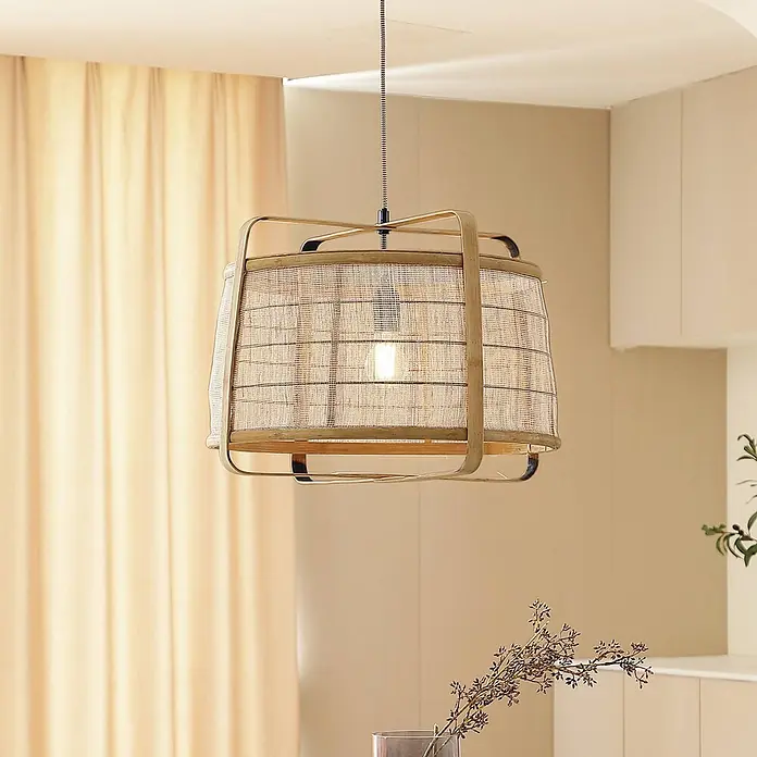 Lindby Pendelleuchte Liriana - L x B x H: 45 x 45 x 35 cm, Holz hell, holz hell, Schwarz, E27 - Eine beleuchtete Pendelleuchte aus geflochtenem Rattan und Metall hängt in einem warmfarbenen Raum.