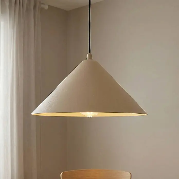 Lindby Pendelleuchte Clarine - creme / amber, beige, E27 - Beige konische Pendelleuchte mit schwarzem Kabel, in einem Raum über einem teilweise sichtbaren Holzstuhl hängend.