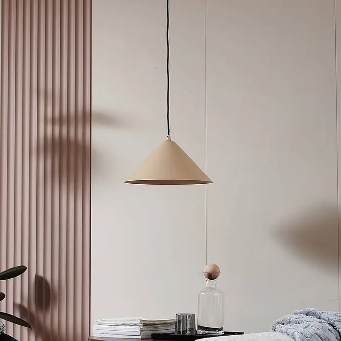 Lindby Pendelleuchte Clarine - creme / amber, beige, E27 - Konische, beigefarbene Pendelleuchte hängt von der Decke und beleuchtet einen modernen Innenraum über einem Tisch mit Accessoires.