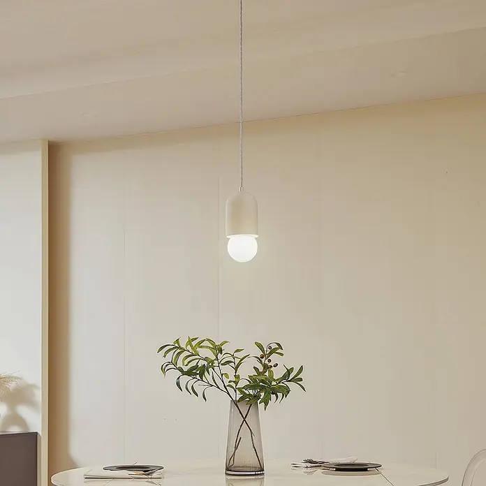 Lindby Pendelleuchte Nielson - creme / amber, beige, weiß, E27 - Moderne weiße, kapselartige Pendelleuchte mit runder Glühbirne, die über einem Esstisch hängt.