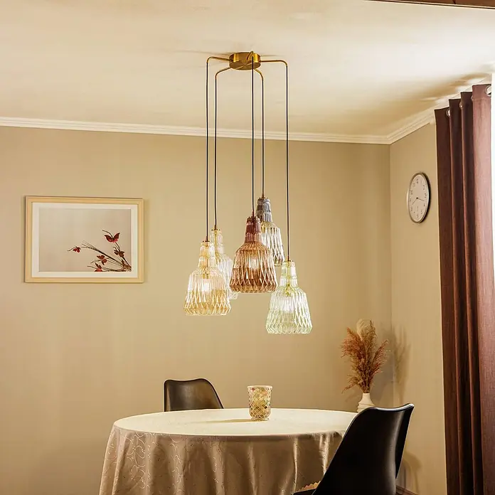 Lindby Pendelleuchte Belarion - L x B x H: 65 x 65 x 35 cm, Multicolour, bernstein, rauchgrau, hellGrün, transparent, Kupfer, E27 - Goldfarbene Mehrfach-Hängeleuchte mit fünf texturierten Glasschirmen in Bernstein, Braun und Klar, über einem gedeckten Esstisch hängend.