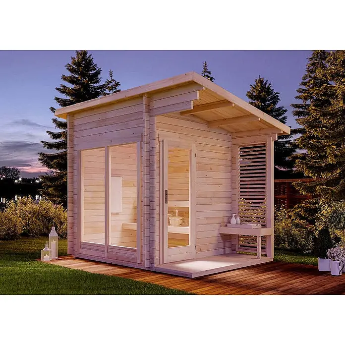 FinnTherm Saunahaus Lizzy S - L x B x H: 251 x 33 x 262 cm - Helle Holz-Außensauna mit großen Glasfenstern, einladendem Interieur und kleiner Veranda, in einem Garten in der Dämmerung.