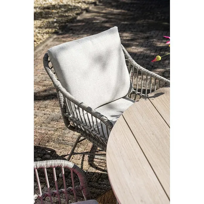 Garden Impressions Gartensessel Margriet - 1 Stk., Stahl, Polyester, Stapelbar, Taupe/Sand, B x T x H: 69,5 x 91 x 59 cm - Grauer Outdoor-Sessel aus Polyrattan mit hellen Kissen und hellem Holztisch auf einer Terrasse.