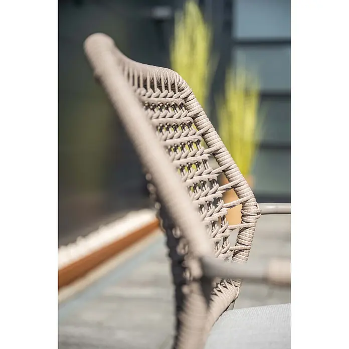 Garden Impressions Gartensessel Swifty - 1 Stk., Stahl, Polyester, Stapelbar, Taupe, B x T x H: 63,5 x 84,5 x 56,5 cm - Nahaufnahme einer hellbeigen, geflochtenen Outdoor-Stuhllehne und Armlehne, die ihre Textur hervorhebt.