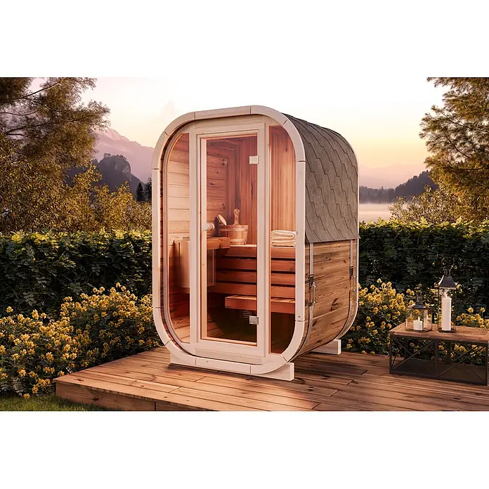 FinnTherm Fasssauna Ellipso S - Holz - Hölzerne Fasssauna mit dunklem Schindeldach, auf einer Terrasse in malerischer Naturumgebung mit Bergen und See.