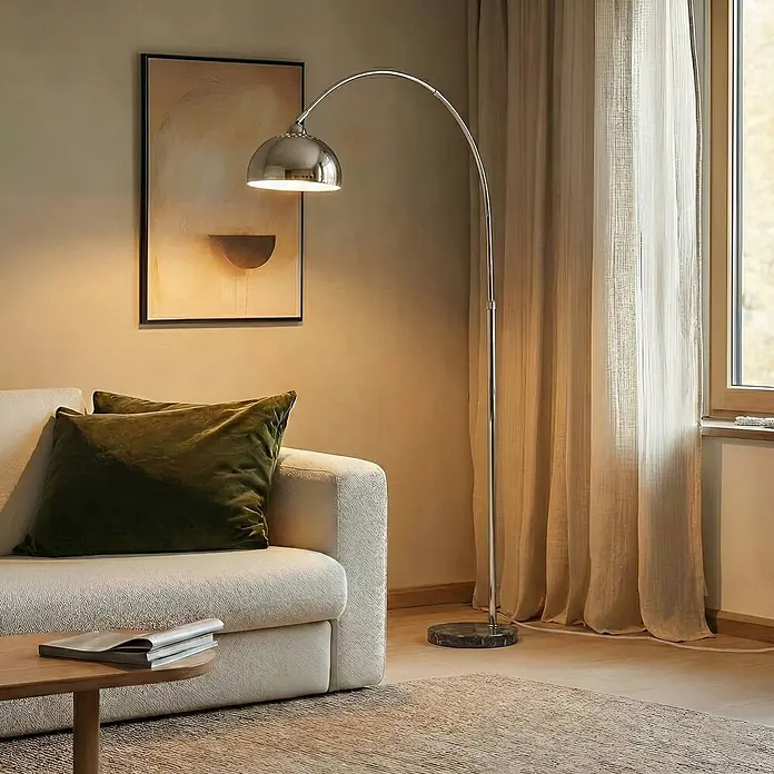 Lindby Stehlampe in chrom, grau, Bogenlampe Wohnzimmer -  - Chromfarbene Bogenstehleuchte mit gewölbtem Schirm, spendet Umgebungslicht neben einem Sofa.