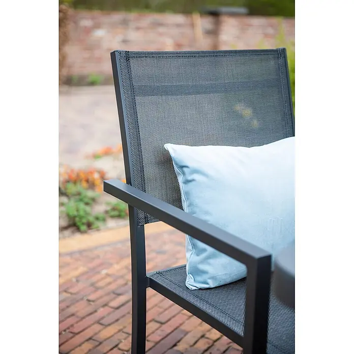 Garden Impressions Stapelstuhl Moon - Aluminium, Schwarz/Anthrazit, B x T x H: 59 x 55 x 91 cm - Dunkelgrauer Outdoor-Stuhl mit Netzrücken und -sitz, einem hellblauen Kissen, auf einer Ziegelterrasse.