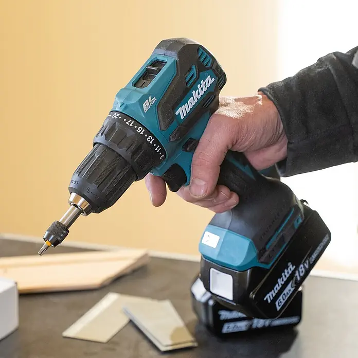 Makita LXT 18V Akku-Bohrschrauber DDF490Z - 18 V, Ohne Akku, 50 Nm - Türkis-schwarzer Makita Akku-Bohrschrauber, von einer Hand gehalten, einsatzbereit mit Schrauberbit.