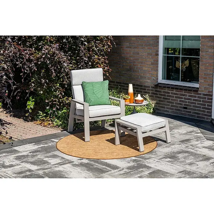Garden Impressions Garten-Positionssessel Max - 1 Stk., Aluminium, Taupe, B x T x H: 78 x 72 x 107 cm - Heller grauer Outdoor-Sessel mit Hocker, weißen Kissen und grünem Kissen auf braunem Rundteppich auf einer Terrasse.