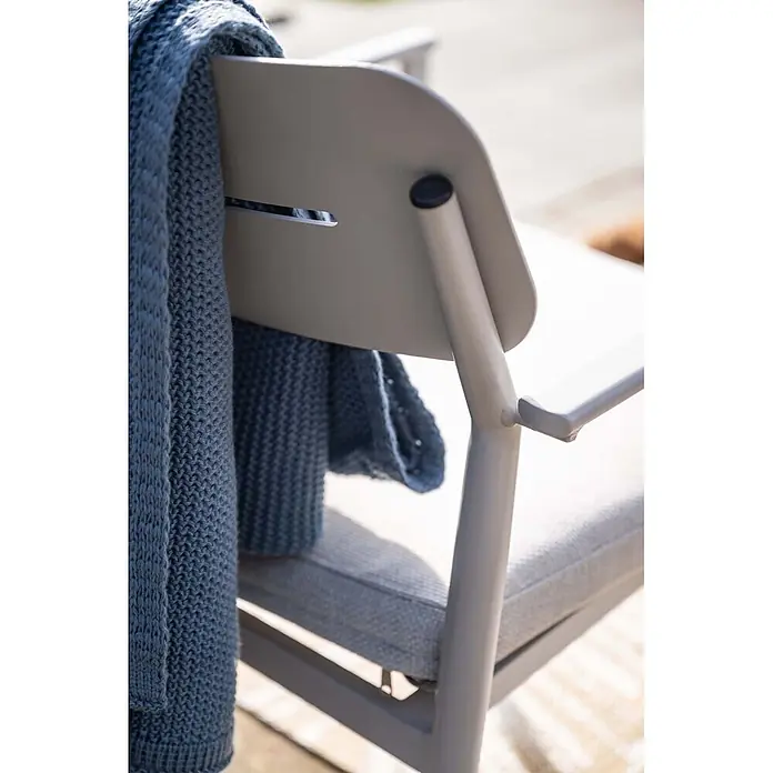 Garden Impressions Loungemöbel-Set Morella - 4 -tlg., Aluminium, Weiß - Blaue Strickdecke über hellgrauem Outdoor-Stuhl mit Kissen, von hinten gesehen.