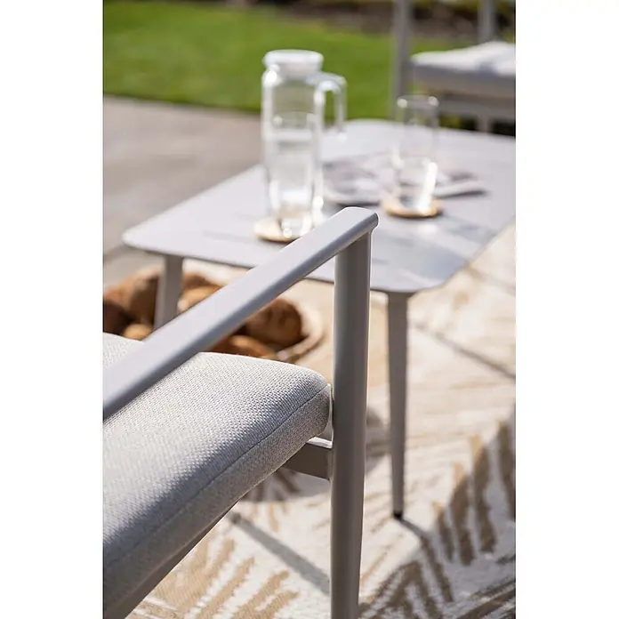 Garden Impressions Loungemöbel-Set Morella - 4 -tlg., Aluminium, Weiß - Heller grauer Outdoor-Sessel mit Stoffpolstern und Metallgestell, auf einer Terrasse mit Tisch und Getränken.