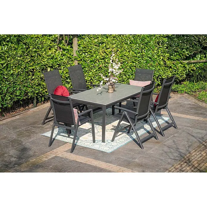 Garden Impressions Stapelstuhl Gala - Aluminium, Schwarz/Anthrazit, B x T x H: 64 x 63 x 93,5 cm - Grauer rechteckiger Gartentisch und sechs dunkle Stühle mit Kissen, auf einem Terrassenteppich.
