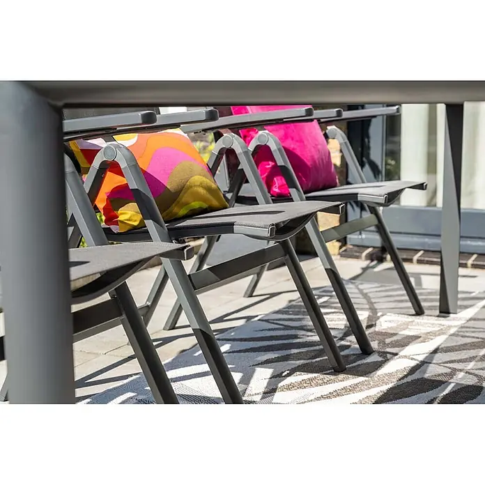 Garden Impressions Garten-Positionssessel Osaka - Aluminium, Klappbar, Schwarz/Anthrazit, B x T x H: 61,5 x 66,5 x 110 cm - Graue Klappstühle für den Außenbereich mit dunkelgrauen Stoffsitzen und bunten Muster- und rosa Kissen auf einer Terrasse.