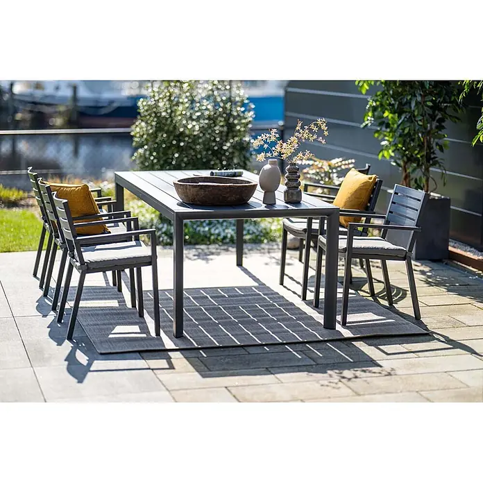 Garden Impressions Stapelsessel Oklahoma - Aluminium, Stapelbar, Dunkelgrau, B x T x H: 56,5 x 55 x 81 cm - Dunkelgraues Outdoor-Esstischset aus Metall mit passenden Stühlen und grauen Kissen auf einer Terrasse. Gelbe Kissen sorgen für Farbtupfer.