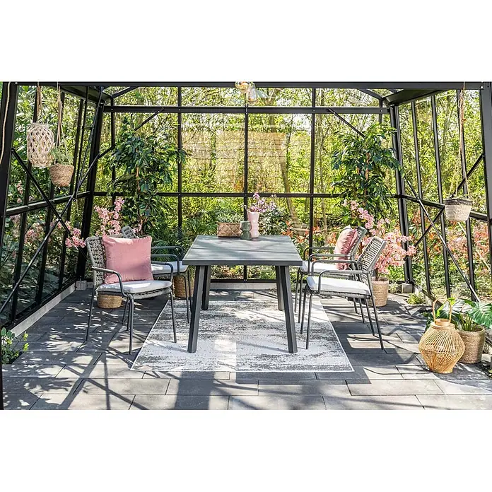 Garden Impressions Gartensessel Swifty - 1 Stk., Stahl, Polyester, Stapelbar, Schwarz, B x T x H: 63,5 x 84,5 x 56,5 cm - Dunkelgraues Outdoor-Esstischset mit Tisch und vier Stühlen in einem Gewächshaus, umgeben von Pflanzen.