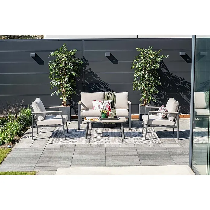 Garden Impressions Loungemöbel-Set Ricca - 4 -tlg., Aluminium, Grau/Schwarz - Moderne graue Outdoor-Sofa, zwei Sessel und Couchtisch mit beigen Kissen auf einer Terrasse.