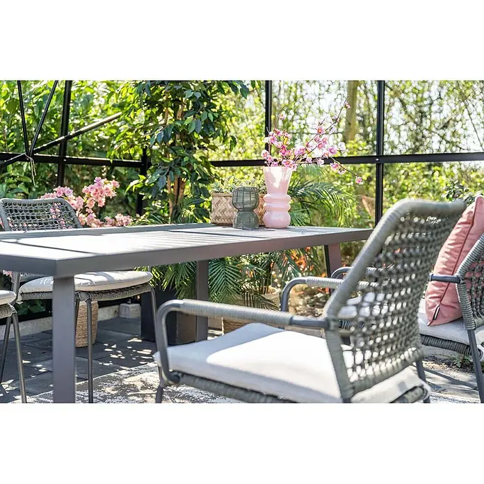 Garden Impressions Gartensessel Swifty - 1 Stk., Stahl, Polyester, Stapelbar, Schwarz, B x T x H: 63,5 x 84,5 x 56,5 cm - Outdoor-Essgruppe: dunkelgrauer Tisch, graue Flechtstühle mit hellen Kissen, umgeben von Grün.
