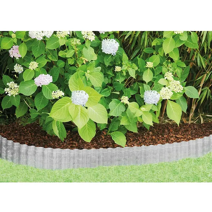 Bellissa Rasenkante Welle - 500 x 20 cm, Metall, Verzinkt - Gartenblick mit Beetbegrenzung aus Metall, umgeben von üppigen Hortensien und Mulch für eine gepflegte Gartengestaltung.