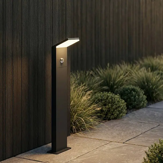 Lucande Außenlaterne Nevio -  - Dunkle Metall-Wegeleuchte mit integriertem Bewegungsmelder, beleuchtet einen Gartenweg.