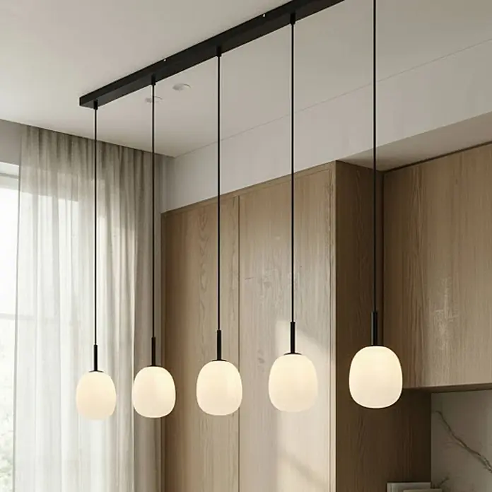 Lindby Pendelleuchte Etiena - L x B x H: 116 x 13 x 15 cm, opalweiß, Schwarz matt, G9 - Fünfflammige lineare Pendelleuchte mit schwarzer Stange und weißen runden Glasschirmen in moderner Küche.