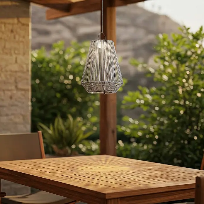Lindby Außenwand- & Deckenleuchte Austas - alu / grau / zink, IP54 - Silbergraue geflochtene Outdoor-Pendelleuchte über einem Holztisch, beleuchtet für den Abend.