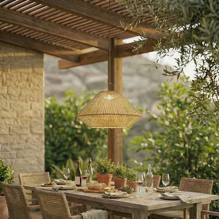 Lindby Außenwand- & Deckenleuchte Austas - creme / amber, IP54 - Große, helle Rattan-Pendelleuchte über einem Esstisch im Freien.
