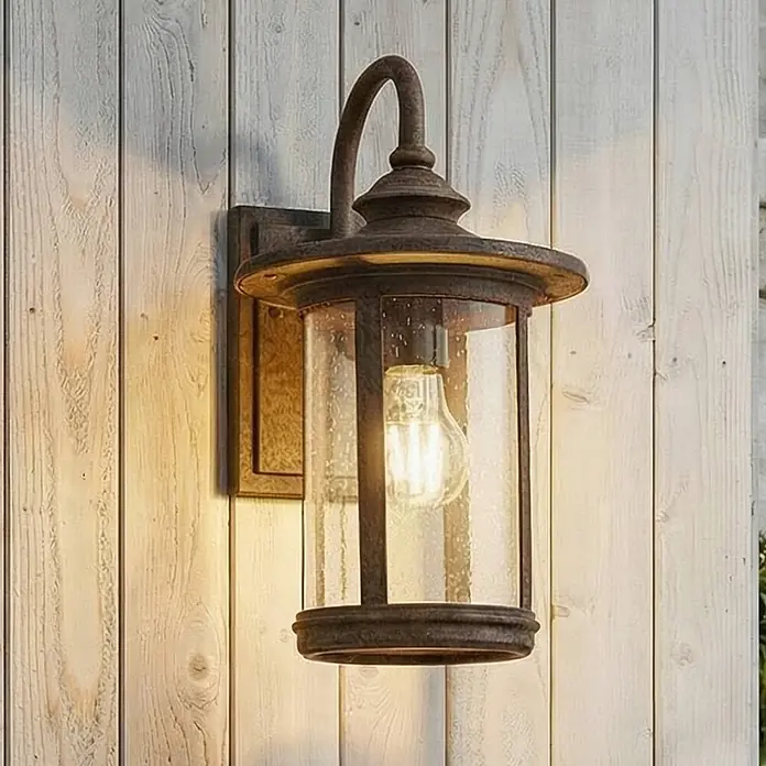 Lindby Außenwandleuchte Zayn - braun / rost, braun / rost, IP23 - Rostbraune Außenwandleuchte aus Metall mit Strukturglas und Edison-Birne, an einer hellen Holzwand montiert.