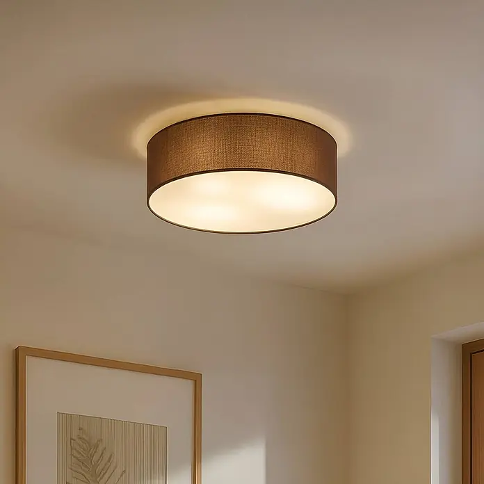 Lindby Deckenleuchte Sebatin - L x B x H: 40 x 40 x 17 cm, braun / rost, E27 - Runde Deckenleuchte mit braunem Stoffschirm, die einen Raum beleuchtet.