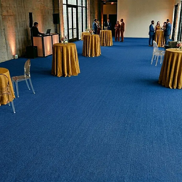 Floordirekt Teppichboden Meterware Sintra - für Messe & Events - Blau - 100 x 500 cm - Breite: 100 cm, Flachgewebe, Polypropylen, Blau - Blauer strukturierter Teppichboden in einem großen Veranstaltungssaal mit goldenen Tischen und Gästen.