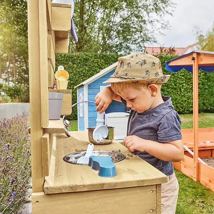 Home Deluxe Matschküche MANDU - Holz, Natur - Ein kleines Kind spielt mit einer hölzernen Matschküche, benutzt Sandspielzeug in Metallschalen.