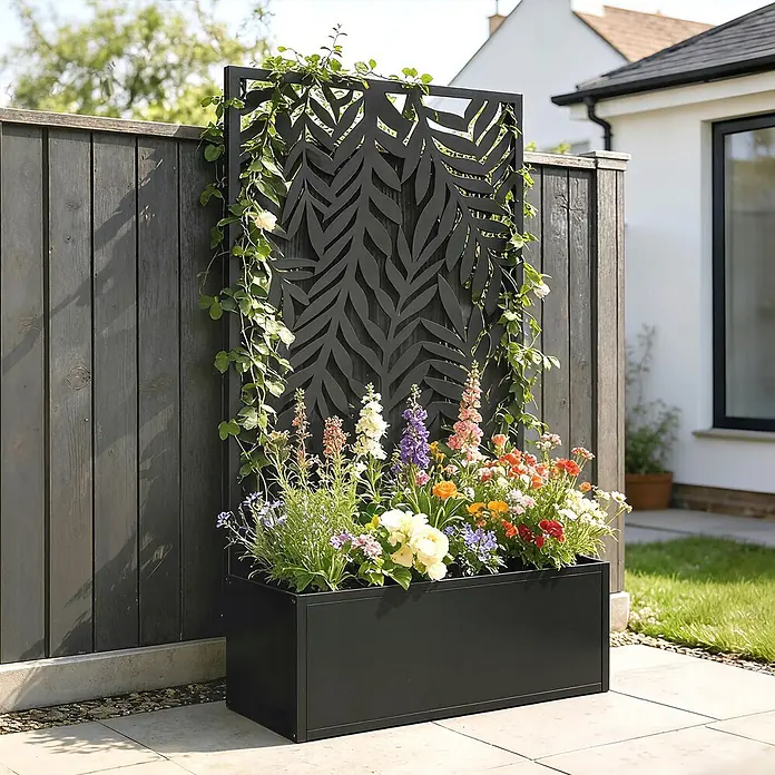 Outsunny Hochbeet - 61 x 23 x 113 cm, Metall, Schwarz - Schwarzer Metall-Pflanzkasten mit integriertem Ziergitter im Blattmuster, gefüllt mit bunten Blumen und Kletterpflanzen.