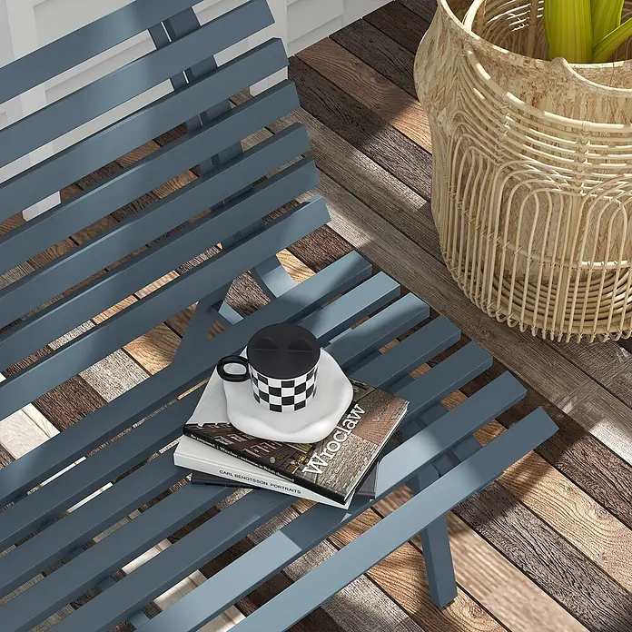 Outsunny Gartenbank - B x T x H: 67 x 67 x 79 cm, Aluminium, Blau - Dunkelblaue Lattenbank, als kleiner Tisch für eine Tasse und Bücher genutzt, auf Holzboden neben einem Weidenpflanzgefäß.
