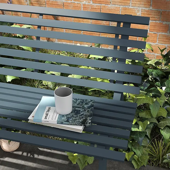 Outsunny Gartenbank - B x T x H: 67 x 67 x 79 cm, Aluminium, Blau - Dunkelgraue Lattenbank für den Garten mit Büchern und Tasse, umgeben von Pflanzen vor einer Ziegelwand.