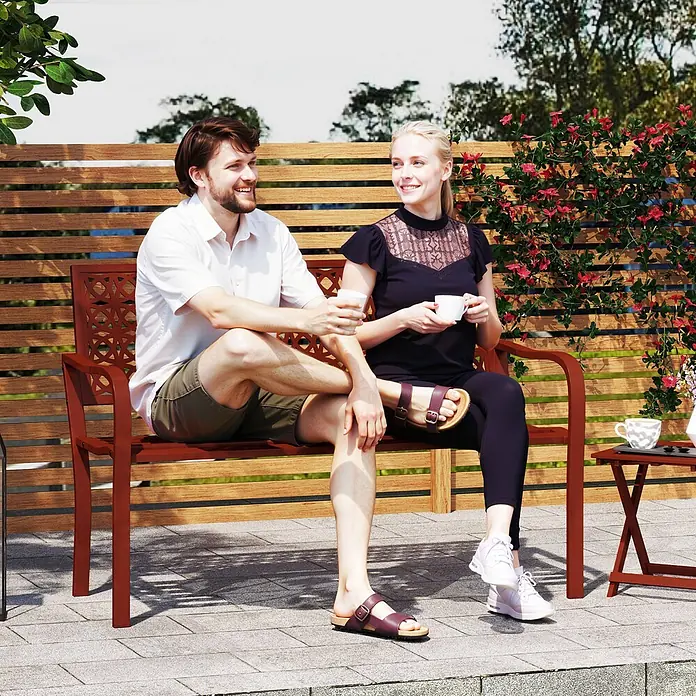 Outsunny Gartenbank - Stahl, Rot - Zwei Personen genießen Getränke auf einer rotbraunen Metallgartenbank mit dekorativer Rückenlehne.